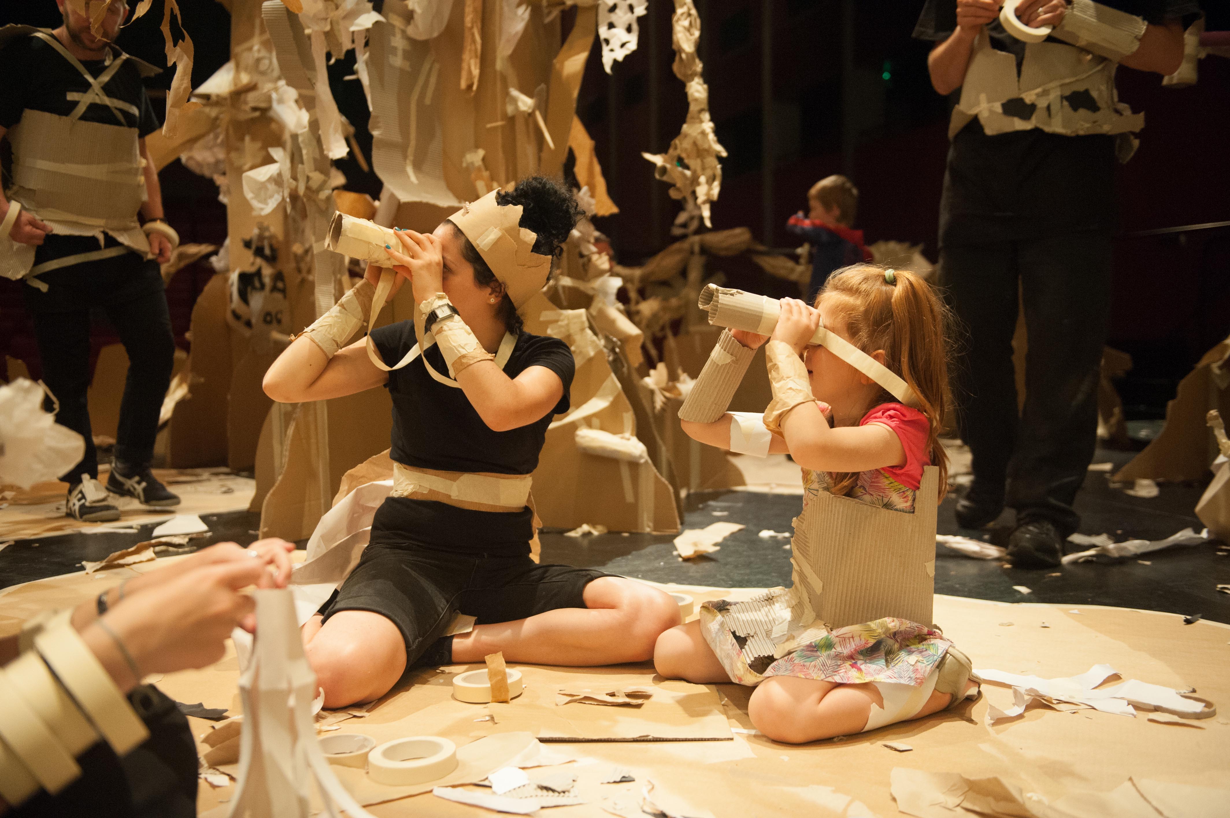 Image from Paper Planet performance of performer and young child Image from Paper Planet performance of performer and young child